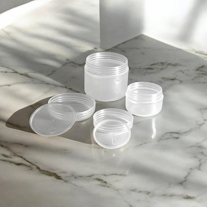 10g and 30g frosted plastic refillable travel pots sitting on a marble surface