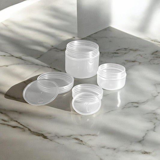 10g and 30g frosted plastic refillable travel pots sitting on a marble surface