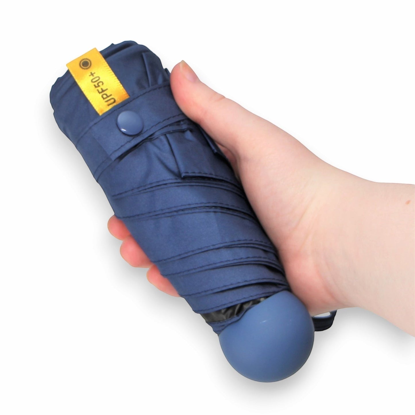 Pakabel compact navy blue umbrella with UPF50+ protection, held in a hand.